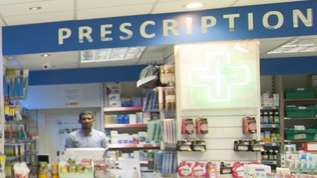 community pharmacy counter with pharmacist in the background