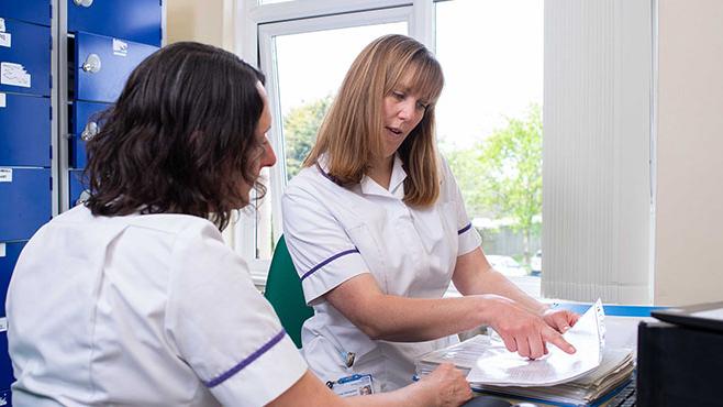 two pharmacists discussing whilst looking at a document