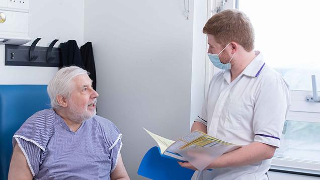 patient talking to pharmacy technician with a folder in hand